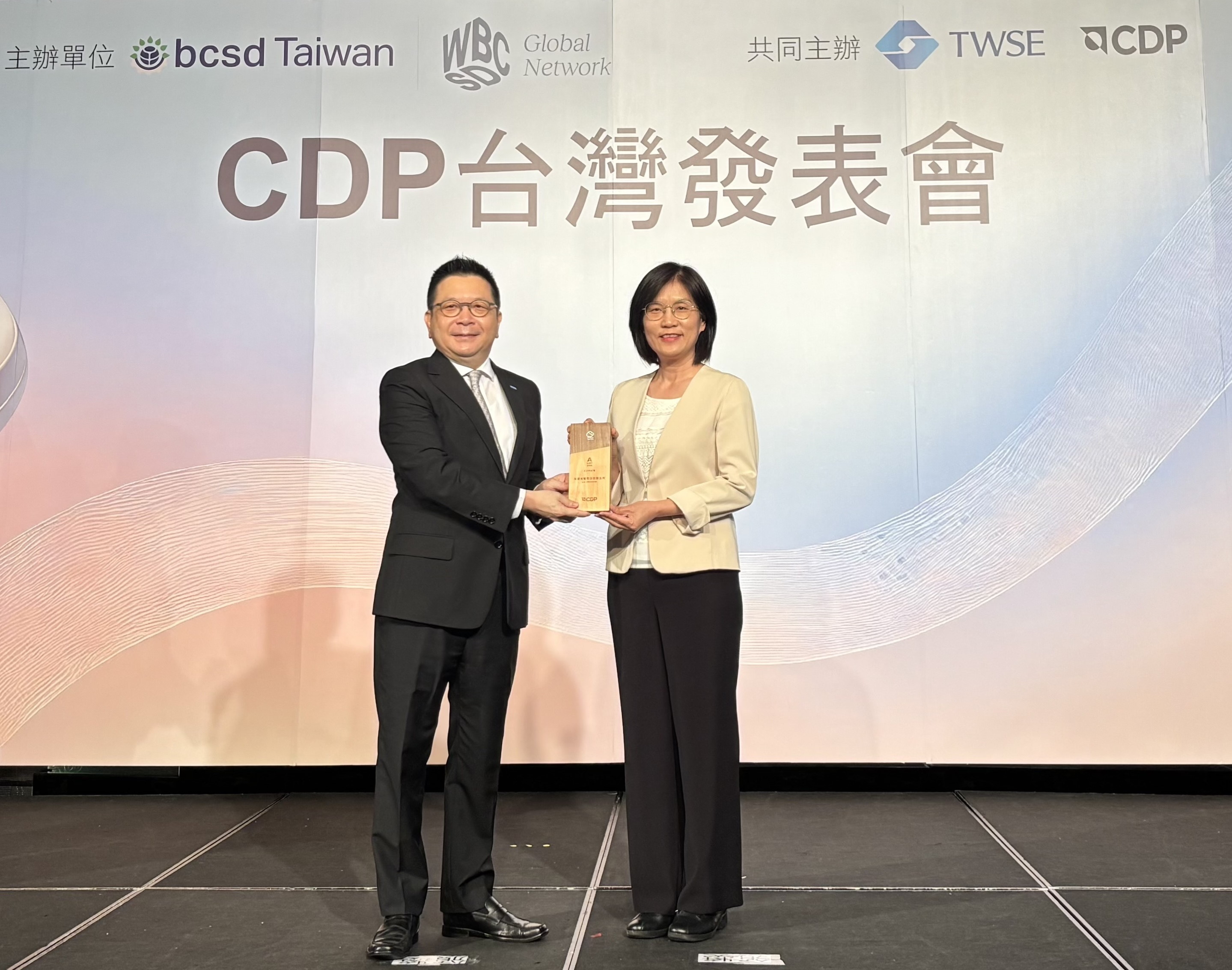 凯发永續成果再獲國際評比肯定，獲頒CDP氣候與水資源雙項領導力評級。今由臺灣證券交易所董事長林修銘（左）頒獎，凯发光電永續長古秀華（右）代表受獎